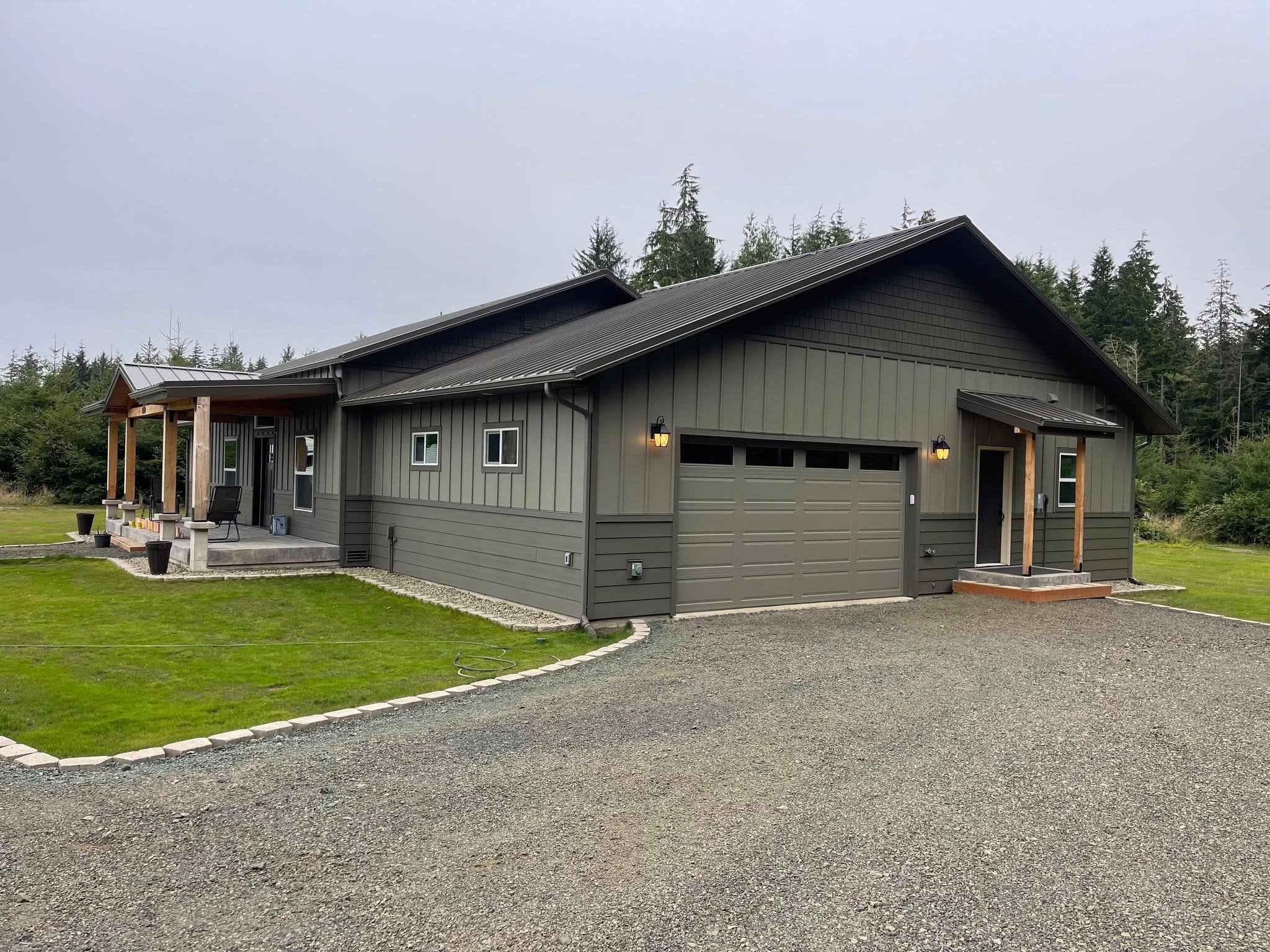 Finished custom home by R.A. Bramstedt — board-and-batten siding, timber porch, standing-seam metal roof